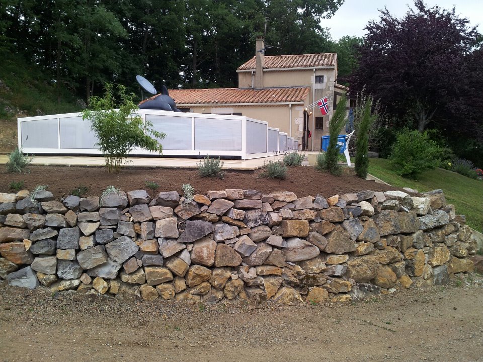 Huset fra veien opp med bassenget foran i bildet